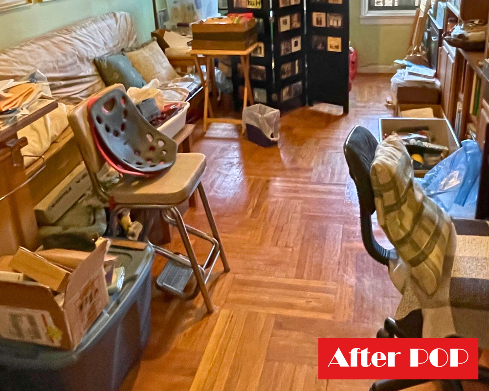 A living space with a couch, tubs and items to be put away